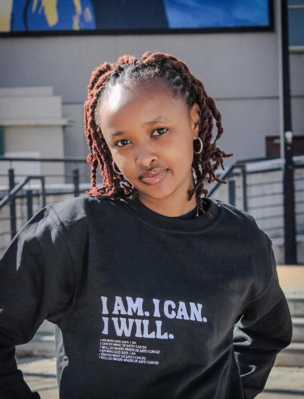 Student wearing the black "I Am. I Can. I Will." sweater on campus